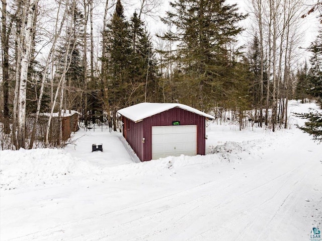 snow covered structure with a garage