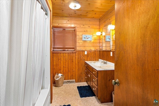 bathroom with wooden walls, wood ceiling, and vanity