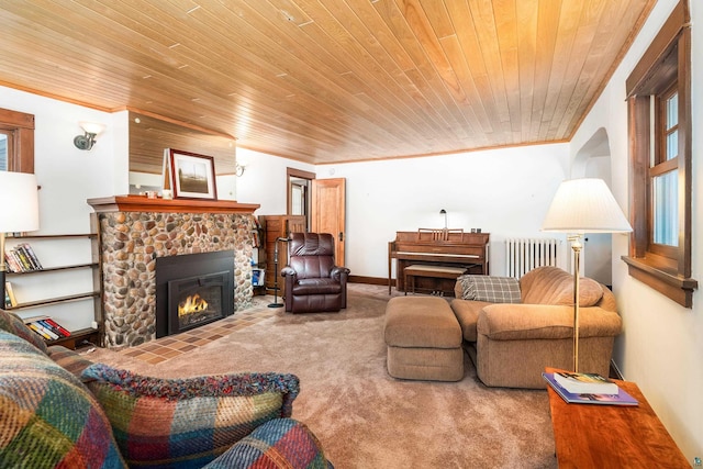 living room with carpet, radiator heating unit, wood ceiling, a stone fireplace, and ornamental molding