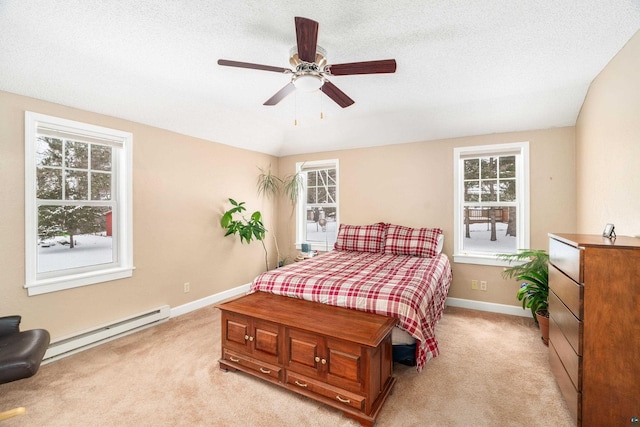 carpeted bedroom with ceiling fan, a baseboard heating unit, multiple windows, and a textured ceiling