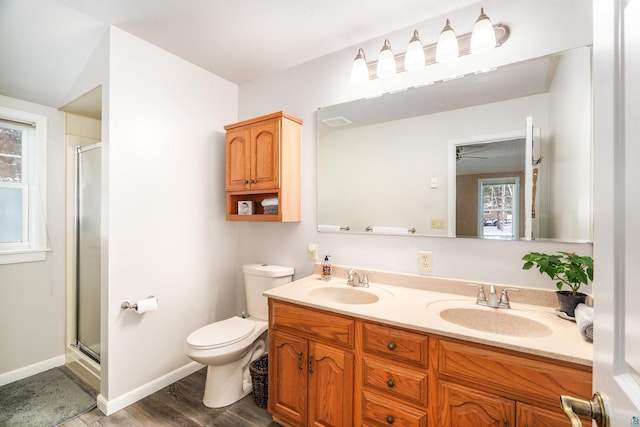 bathroom with toilet, hardwood / wood-style flooring, a shower with door, ceiling fan, and vanity