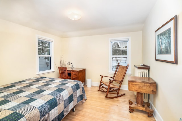 bedroom with multiple windows and light hardwood / wood-style flooring