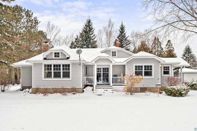 snow covered house featuring a garage