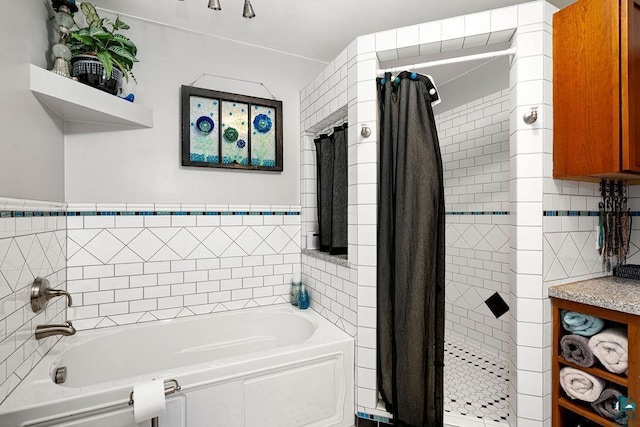 bathroom with tile walls and separate shower and tub