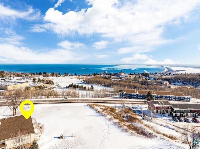 snowy aerial view featuring a water view