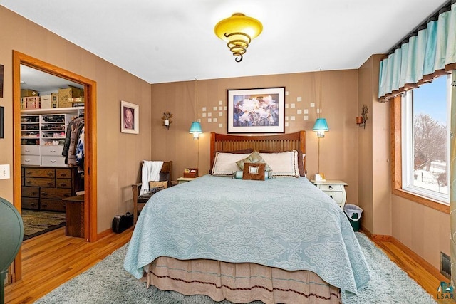 bedroom featuring light hardwood / wood-style floors, a closet, and a walk in closet