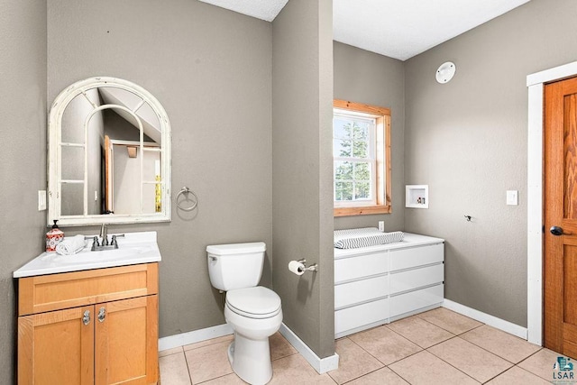 bathroom with toilet, vanity, and tile patterned floors