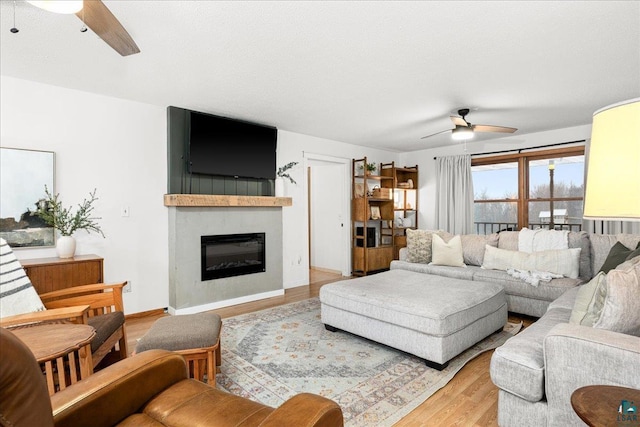 living room with ceiling fan and light wood-type flooring