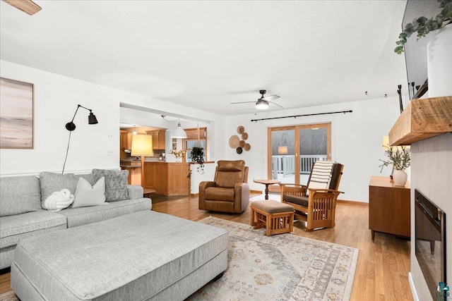 living room with ceiling fan and light hardwood / wood-style flooring