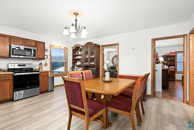 dining area featuring a notable chandelier and light wood-type flooring