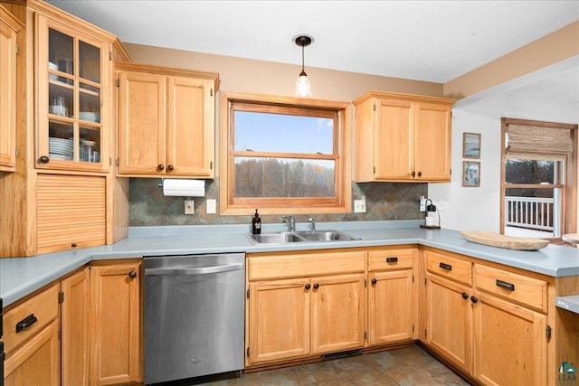 kitchen featuring sink, stainless steel dishwasher, backsplash, and decorative light fixtures