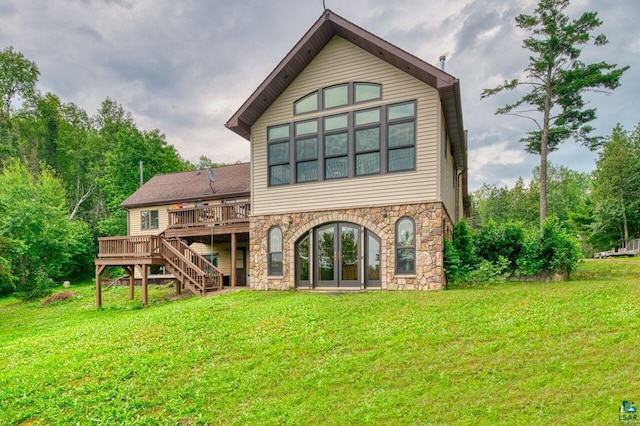 back of property featuring a wooden deck, a lawn, and french doors