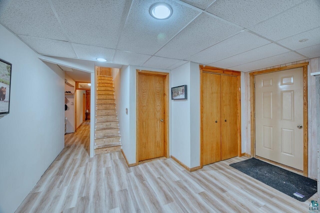 interior space featuring a paneled ceiling and light hardwood / wood-style flooring