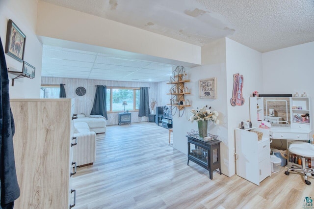 living room featuring light hardwood / wood-style floors and a drop ceiling