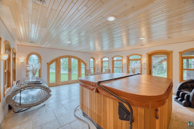 interior space with french doors, a center island, and wooden ceiling