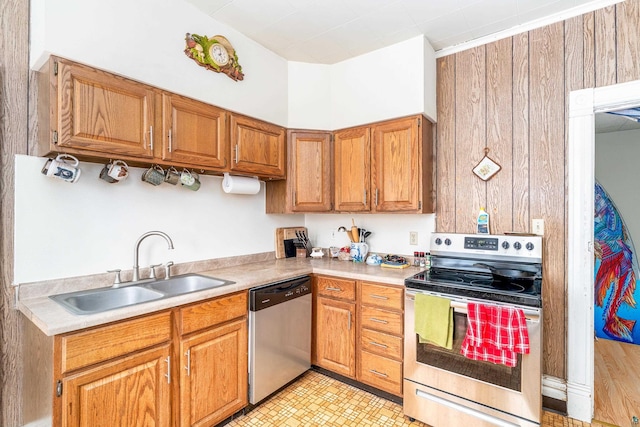 kitchen featuring wood walls, sink, and stainless steel appliances