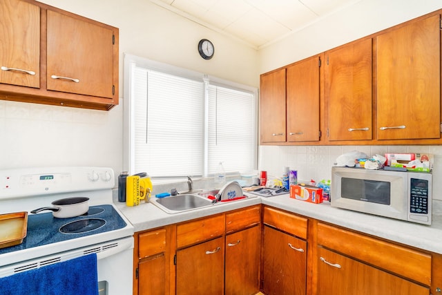 kitchen with a wealth of natural light, white electric range oven, and sink