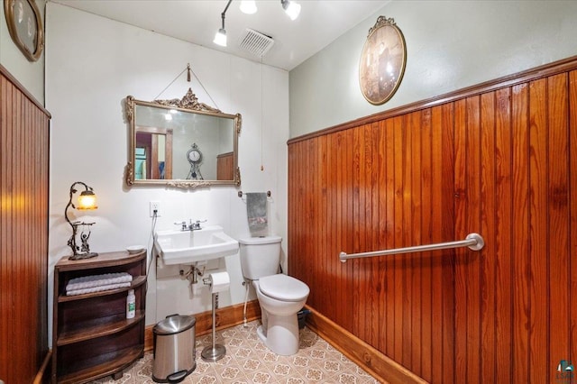 7596 Werner Rd, Virginia, MN 55720 - bathroom with sink, toilet, wood walls, and tile patterned floors