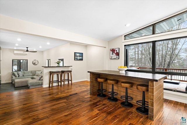 dining room featuring an AC wall unit and dark wood-type flooring