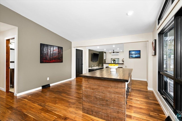 kitchen with a kitchen island, lofted ceiling, and dark hardwood / wood-style flooring