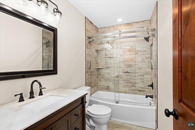 full bathroom featuring vanity, toilet, and bath / shower combo with glass door