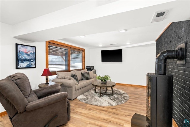 living room with hardwood / wood-style flooring and a wood stove