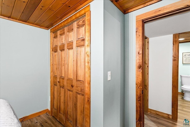 hallway with light hardwood / wood-style flooring and wooden ceiling