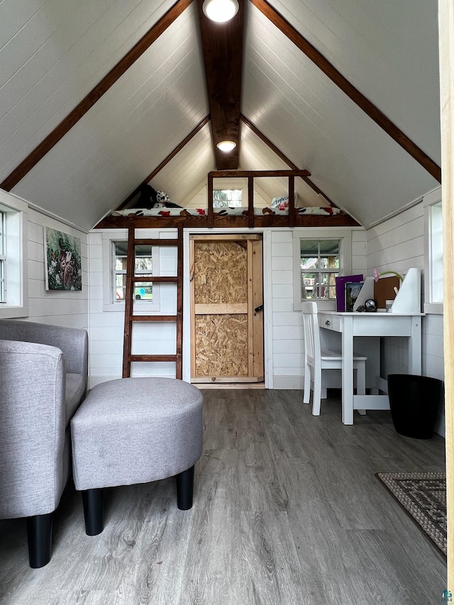 sitting room featuring a wealth of natural light, wood walls, hardwood / wood-style floors, and vaulted ceiling with beams