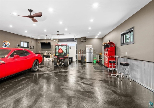 garage featuring ceiling fan and stainless steel refrigerator