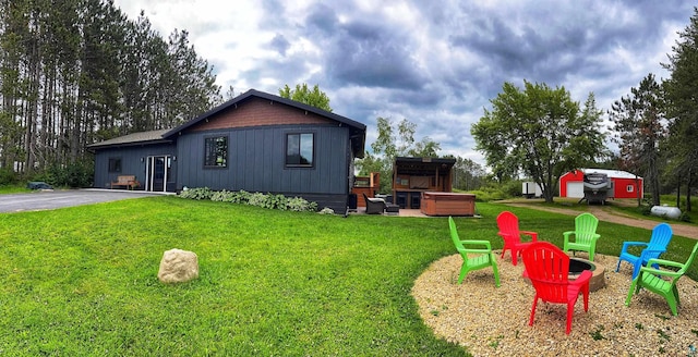 exterior space featuring a jacuzzi and a lawn