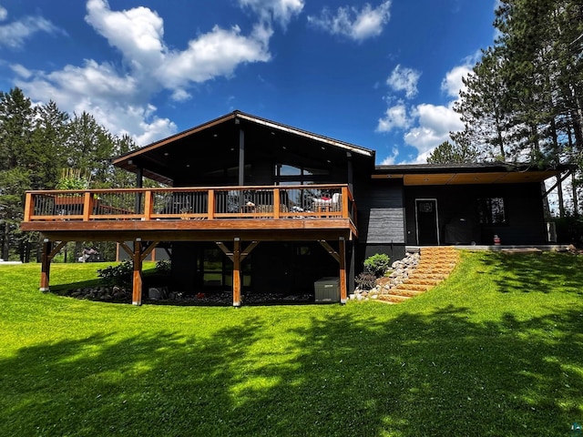 rear view of house featuring a lawn and a wooden deck