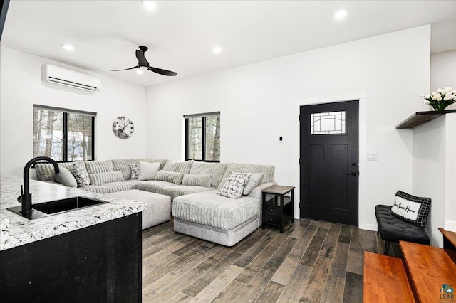 living room featuring sink, ceiling fan, and an AC wall unit