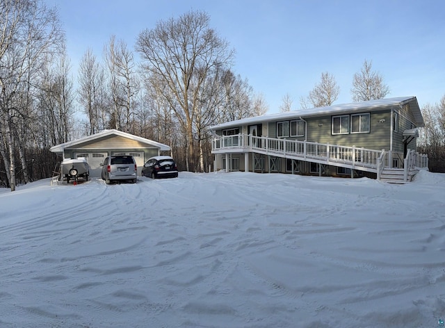 view of snow covered exterior with a garage and a deck