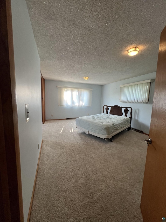 bedroom featuring light colored carpet and a textured ceiling