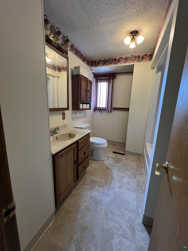 bathroom featuring vanity, toilet, and a textured ceiling