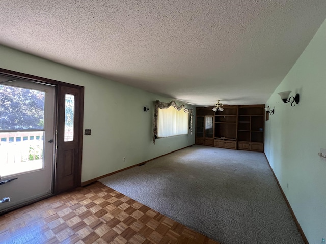 foyer entrance with light parquet flooring, a textured ceiling, and a wealth of natural light