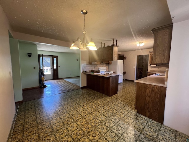 kitchen featuring a chandelier, hanging light fixtures, white appliances, kitchen peninsula, and a textured ceiling