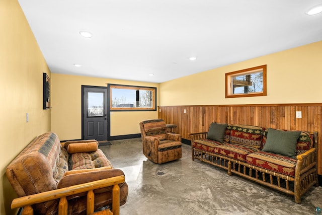 living room featuring concrete flooring and wood walls