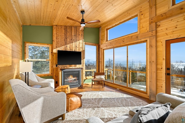 living room with wood ceiling, wooden walls, and high vaulted ceiling