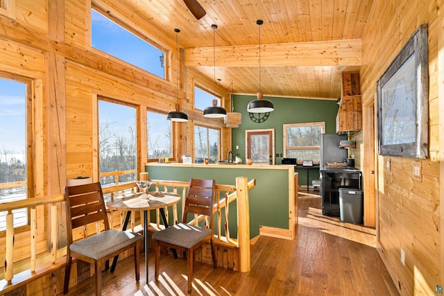 dining space with lofted ceiling, hardwood / wood-style floors, wooden walls, and wooden ceiling