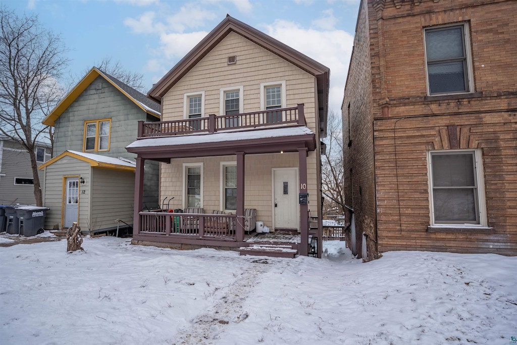 view of front property with a porch and a balcony