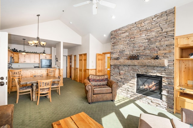 carpeted living room featuring vaulted ceiling, a stone fireplace, ceiling fan with notable chandelier, and wood walls