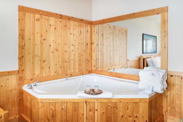 bathroom featuring a tub and wood walls