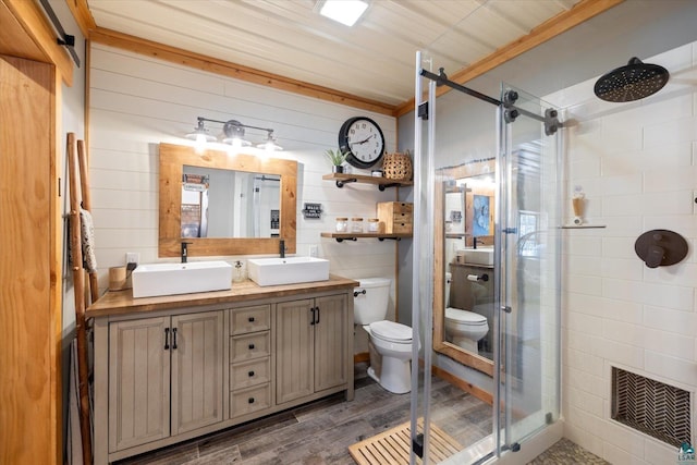 bathroom with wood-type flooring, a shower with door, toilet, and wood walls