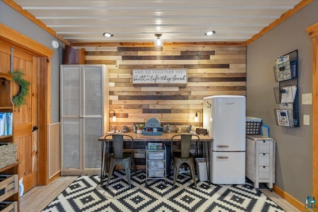 office featuring light hardwood / wood-style floors and wood walls