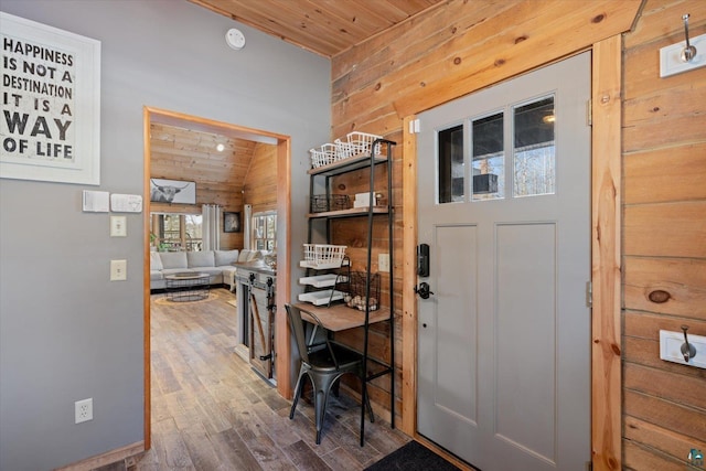 entryway featuring wood-type flooring, wooden ceiling, and wooden walls