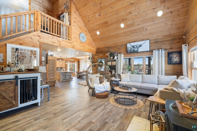 living room with hardwood / wood-style flooring, wooden walls, high vaulted ceiling, and wooden ceiling