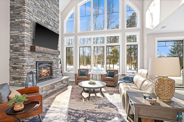 living room with a towering ceiling and a fireplace