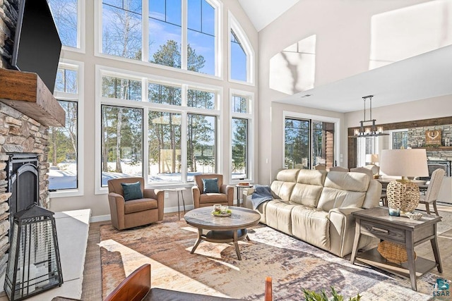 sunroom / solarium with lofted ceiling, a notable chandelier, and a fireplace