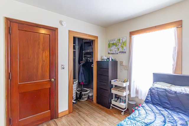 bedroom with light hardwood / wood-style floors and a closet